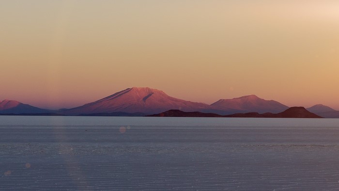Mountains over salt flats at sunset