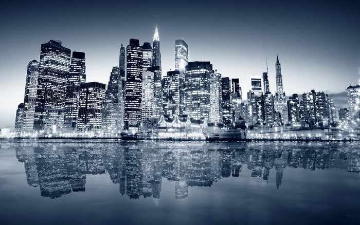 New York City skyline at night with water reflection