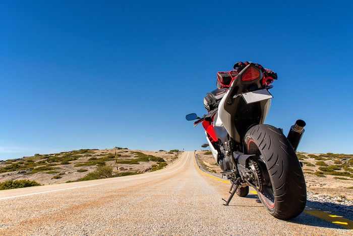 Honda CBR motorcycle on a road under a clear blue sky