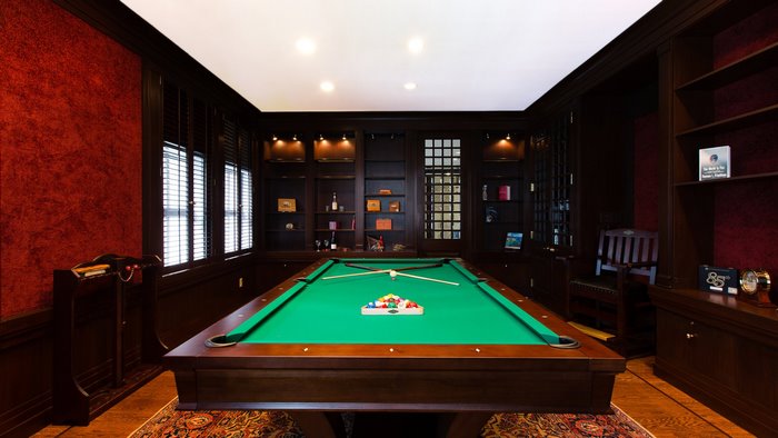 Billiard room with pool table and bookshelves