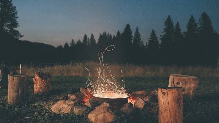Campfire with sparks and logs at night
