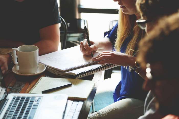 People collaborating and taking notes at a table