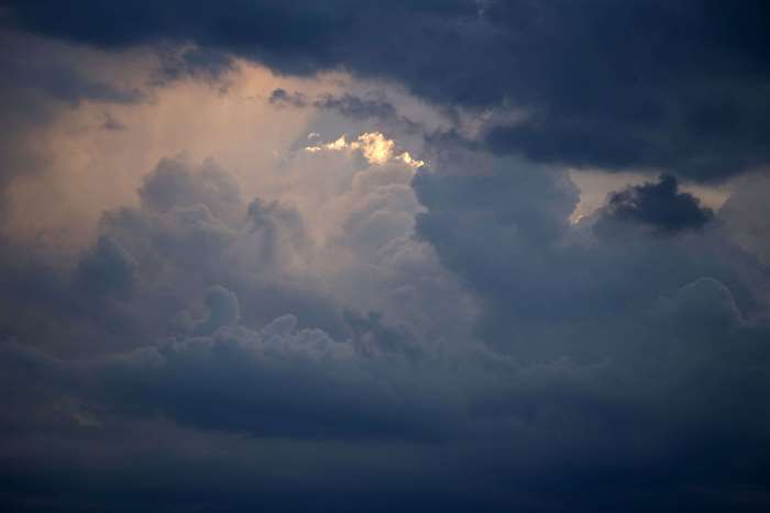 Dark storm clouds with sunlight breaking through 4K