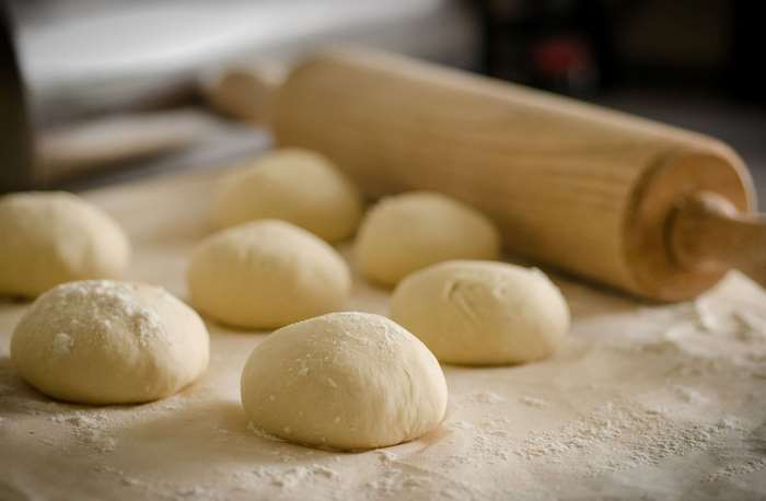 Dough balls and rolling pin on floured surface 4K