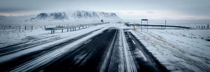 Snowy highway in Iceland with mountains