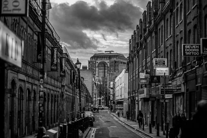 Black and white street scene with university banners and buildings