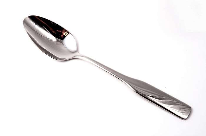 Shiny metal spoon on a white background