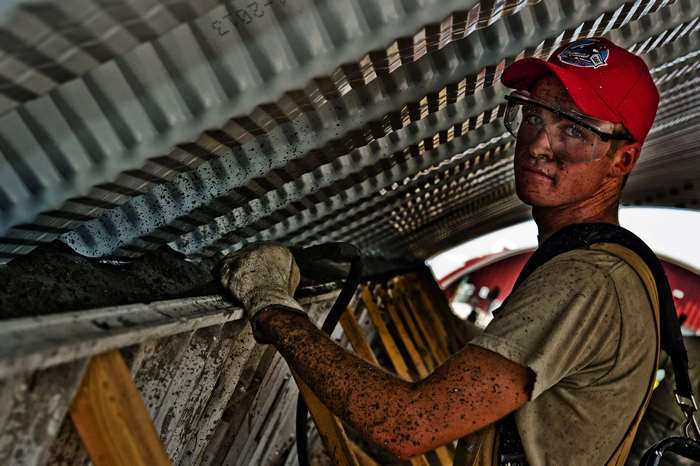 Construction worker with dirty face and red hat