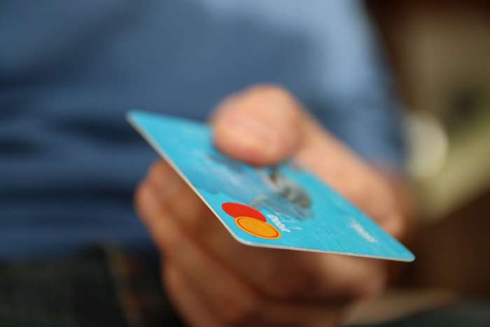 Hand holding a Mastercard debit card