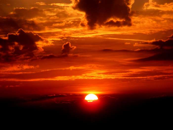Sunset with dramatic clouds and bright sun