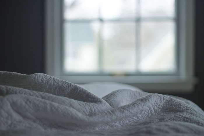 Textured blanket on a bed near a window