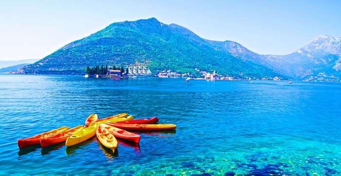 Kayaks on the sea with mountains and islands in Montenegro 4K