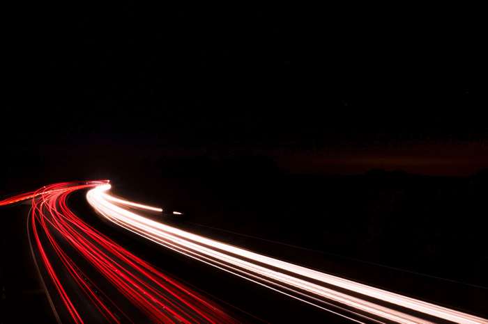 Long exposure of car lights on a dark road at night