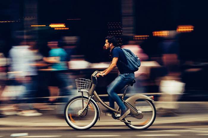 Man riding a bicycle in a busy city street