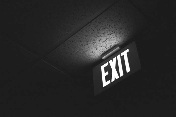 Glowing EXIT sign on a dark ceiling