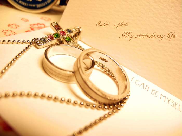 Wedding rings and cross necklace on paper