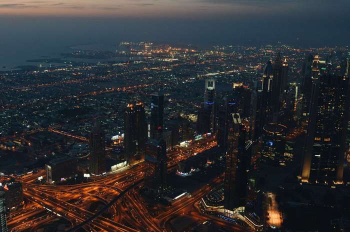 Aerial view of a city at night with skyscrapers and highways