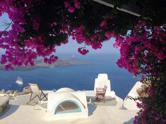 Santorini Greece patio with flowers and sea view