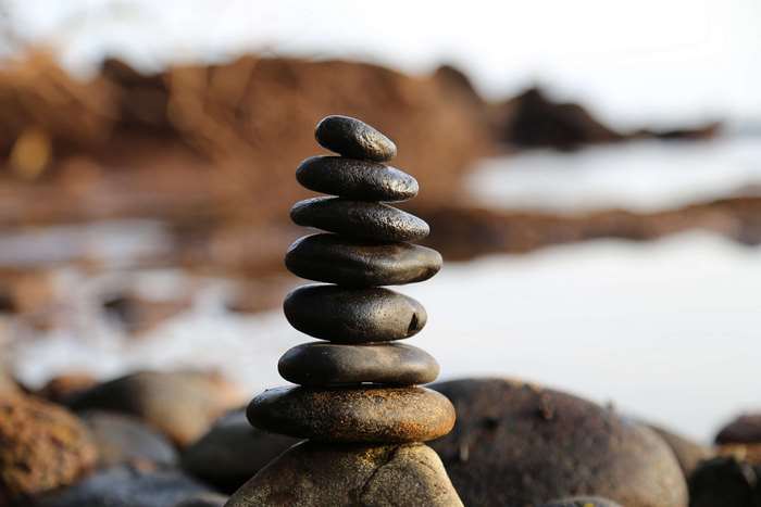 Stack of smooth, dark stones on a rocky shore