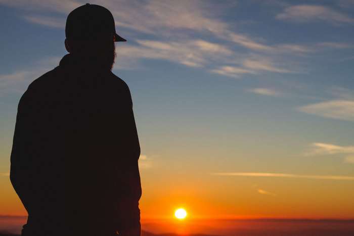 Man in silhouette watching the sunset
