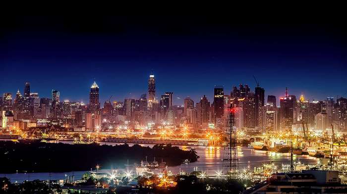 Cityscape skyline with illuminated skyscrapers at night over a river