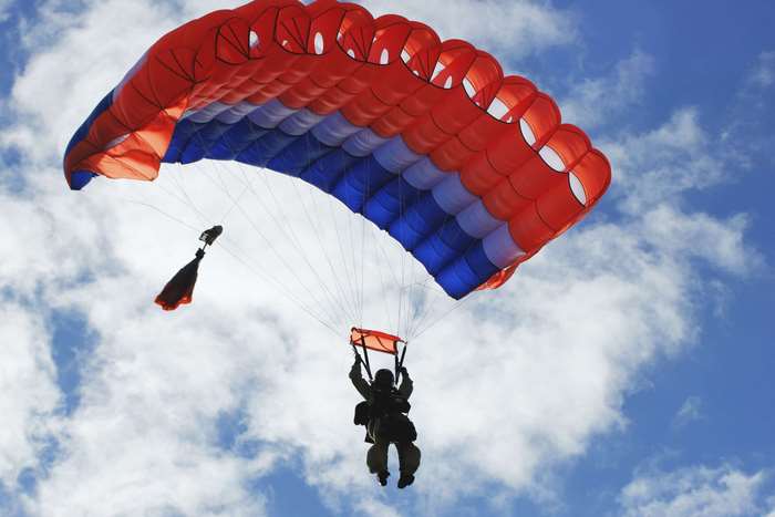 Smoke jumper with parachute in the sky