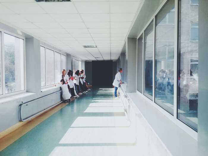 People in a hospital hallway with large windows