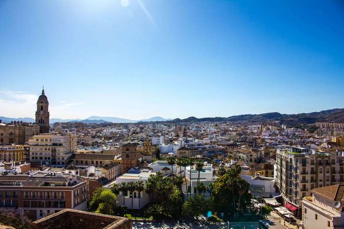 Malaga cityscape with cathedral tower and mountains, Spain 4K