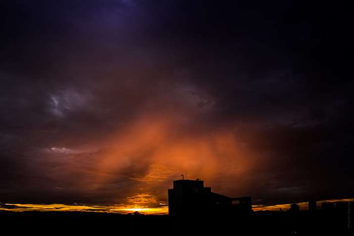 Sunset over city skyline with dramatic clouds