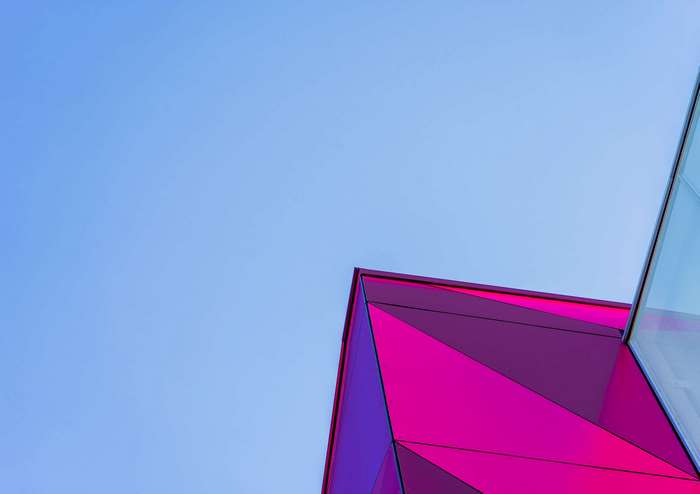 Geometric Pink Building Against Blue Sky