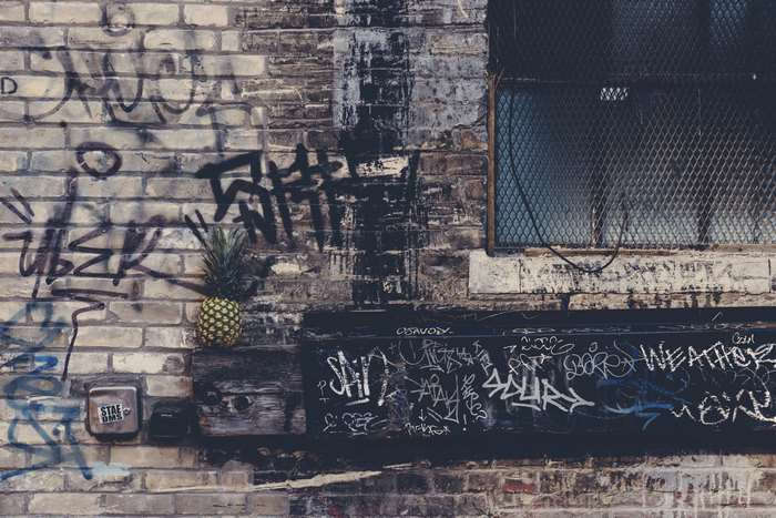 Pineapple on a graffiti-covered brick wall