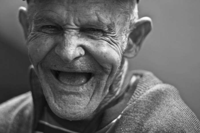 Elderly man laughing with deep wrinkles