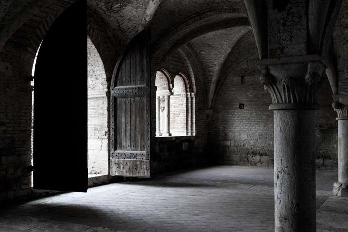 Gothic Abbey Interior with Large Wooden Doors and Arches