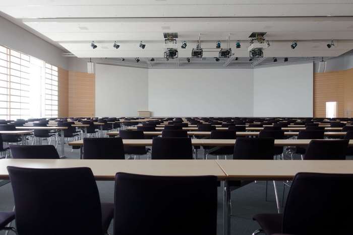Empty conference room with rows of tables and chairs