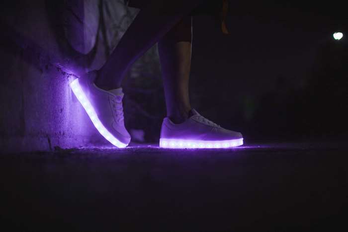 Person wearing white LED sneakers at night