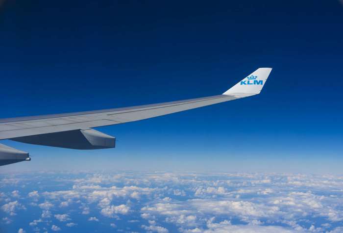 KLM airplane wing flying over clouds