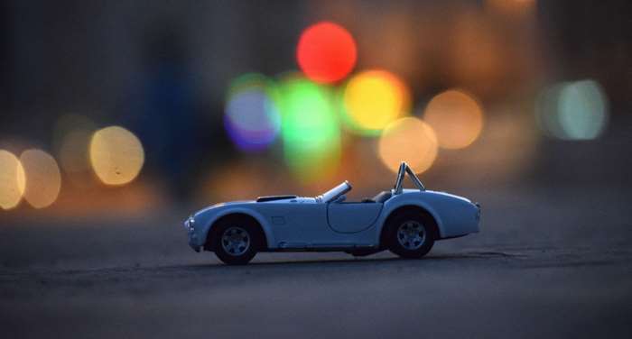 White vintage toy car with bokeh background