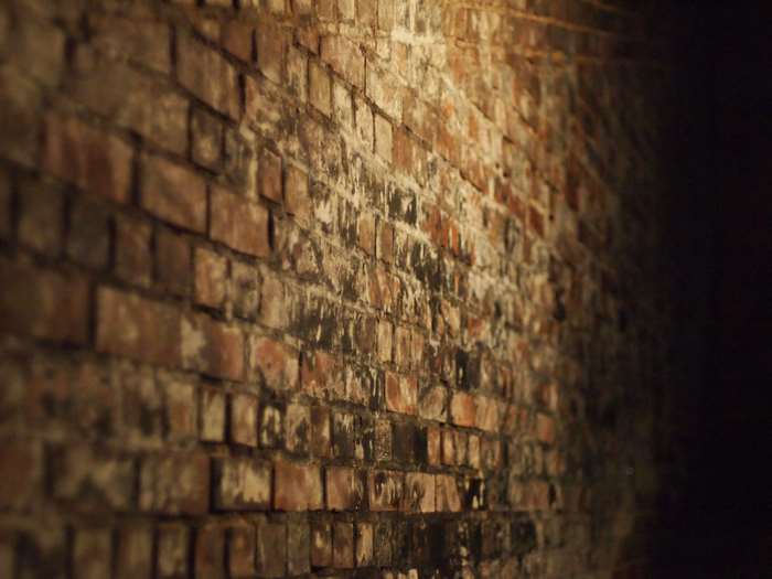 Old brick wall in a dark tunnel