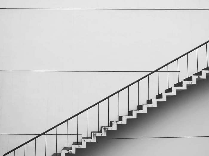 Staircase with handrails against a white wall