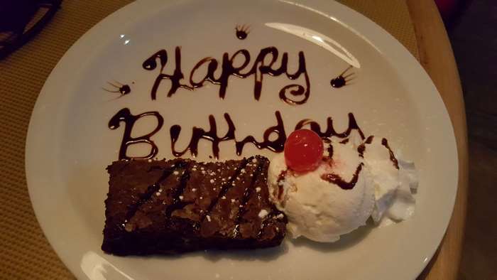 Happy Birthday brownie with ice cream on a plate