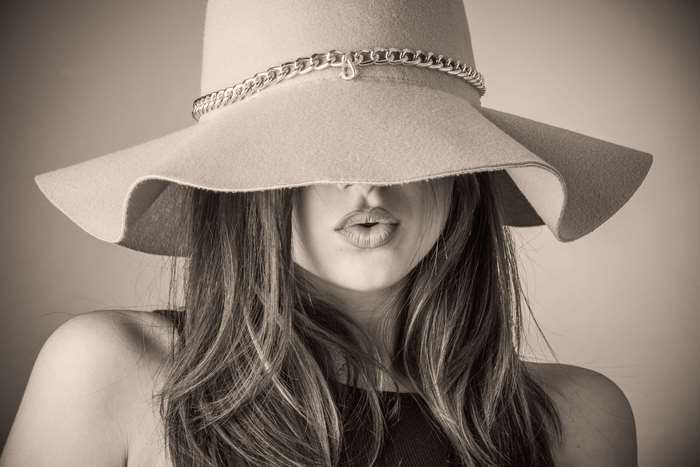 Elegant Woman with Wide-Brimmed Hat Covering Eyes 4K