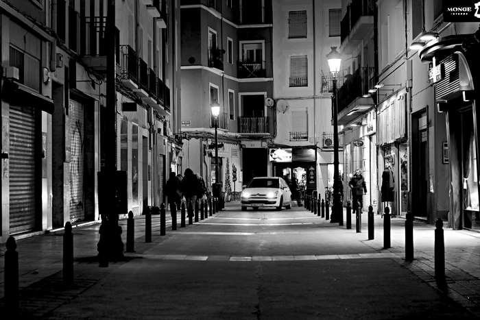 Car driving down a narrow street at night in Saragossa