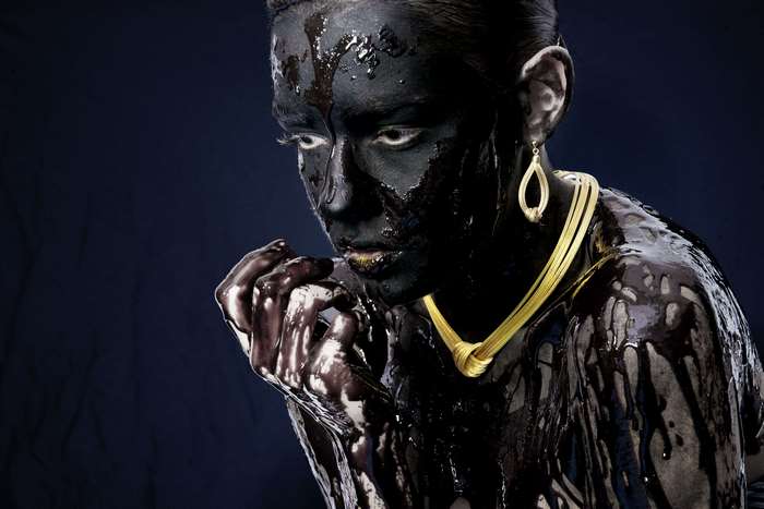 Model with black body paint and gold jewelry