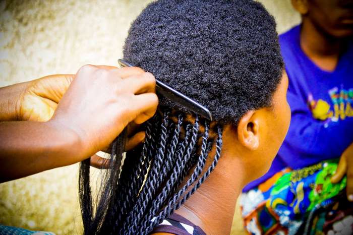 Woman braiding another woman's hair