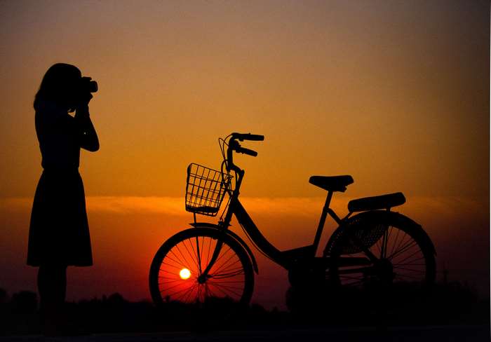 Silhouette of Woman Cycling at Sunset 4K