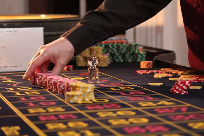 Casino croupier arranging chips on roulette table