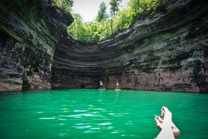 People paddleboarding in a cave at Pictured Rocks National Lakeshore