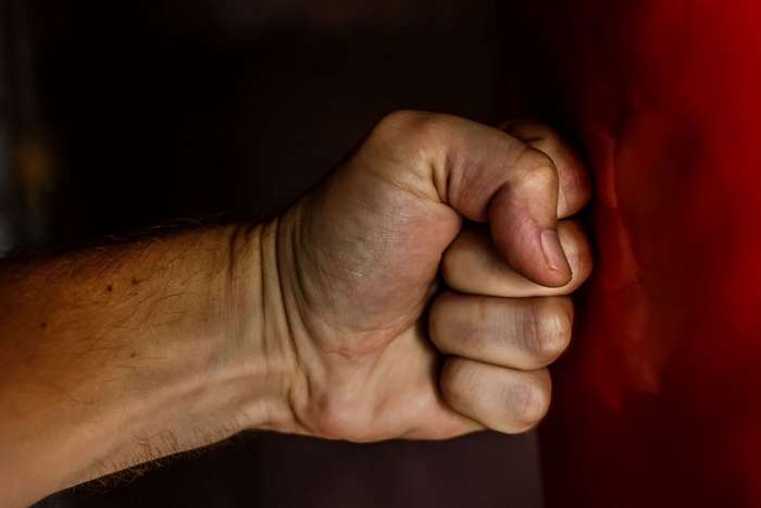 Clenched fist hitting a red surface