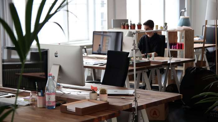 Man working at a desk in a modern office with iMac