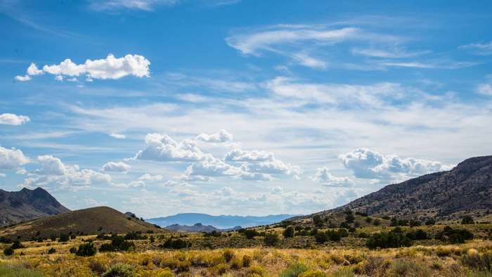 Desert hills under a blue sky with clouds